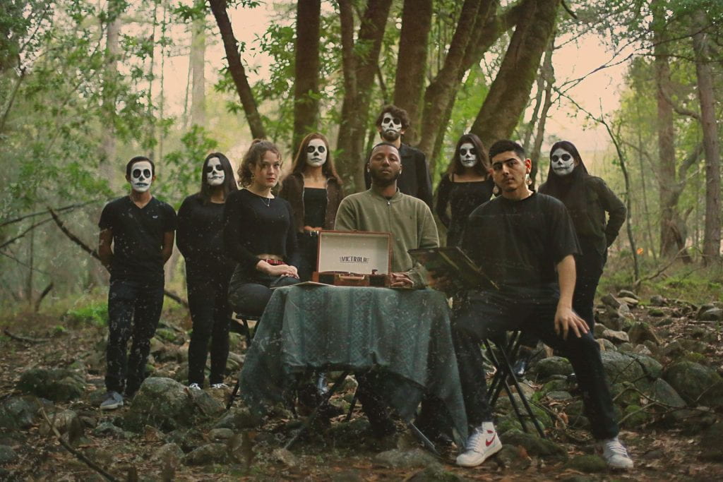 group in death costumes in wooded environment
