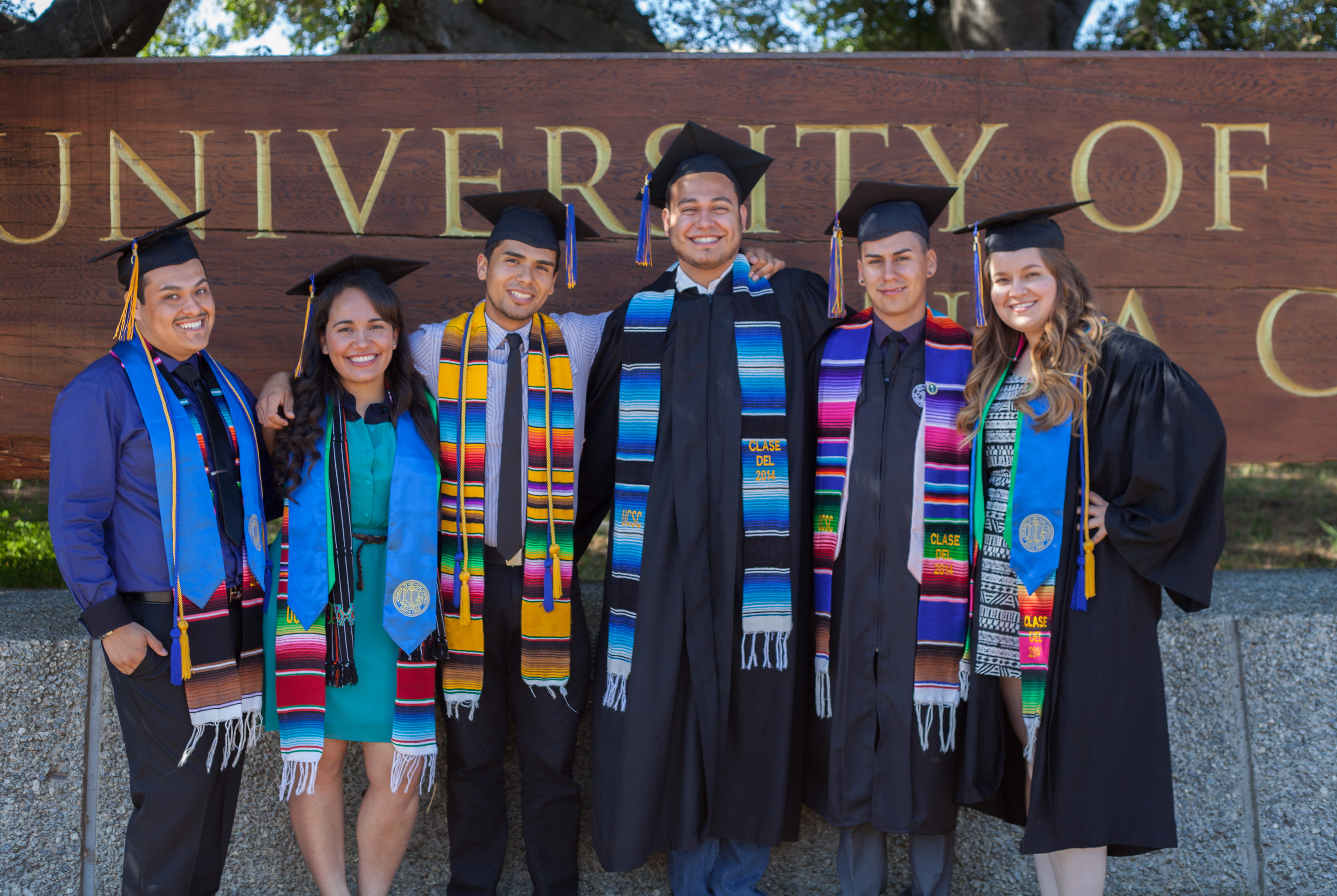 graduate students at graduation in front of ucsc sign